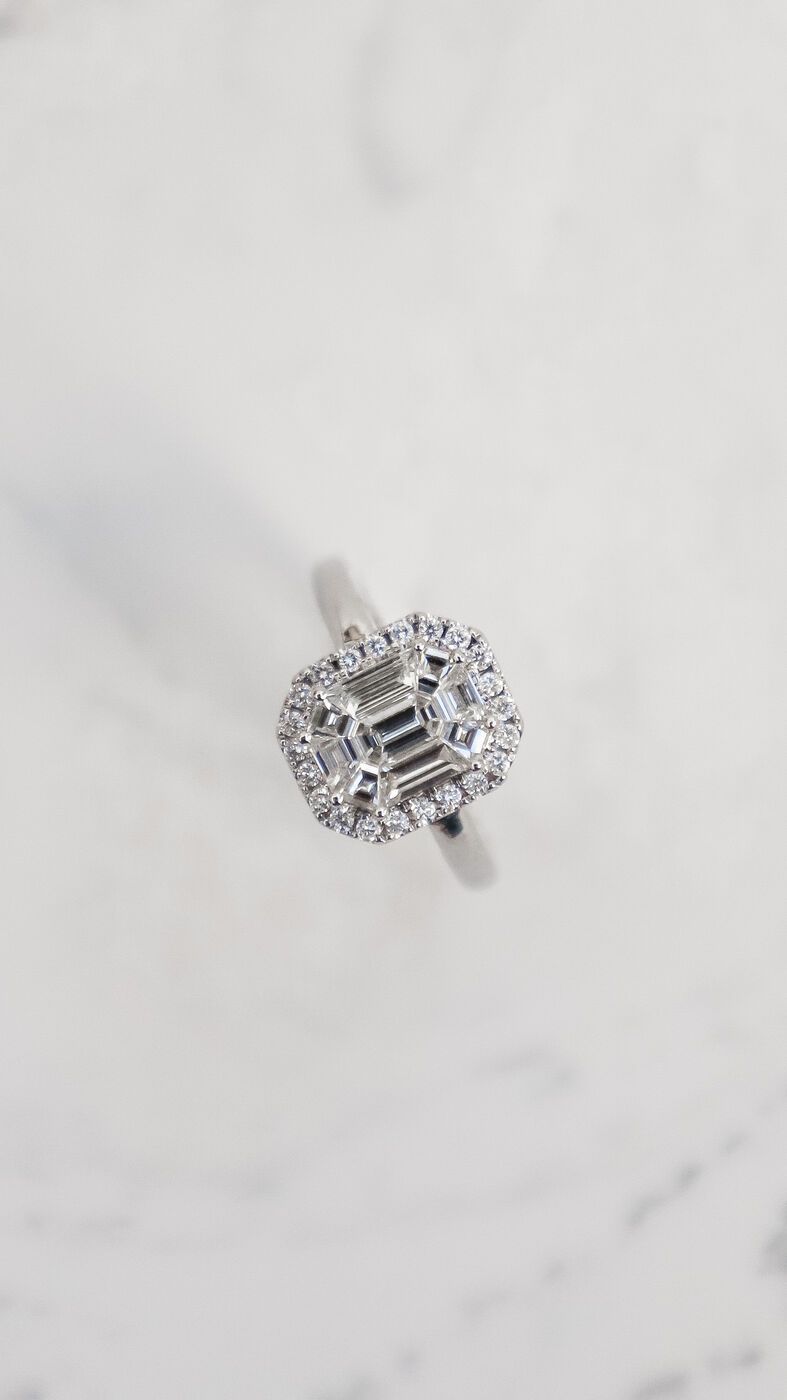 Diamond halo ring, top-down angle on marble