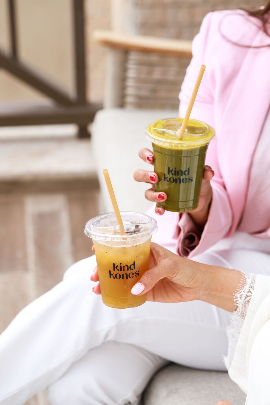 Woman holding a matcha and an iced tea from Kind Kones