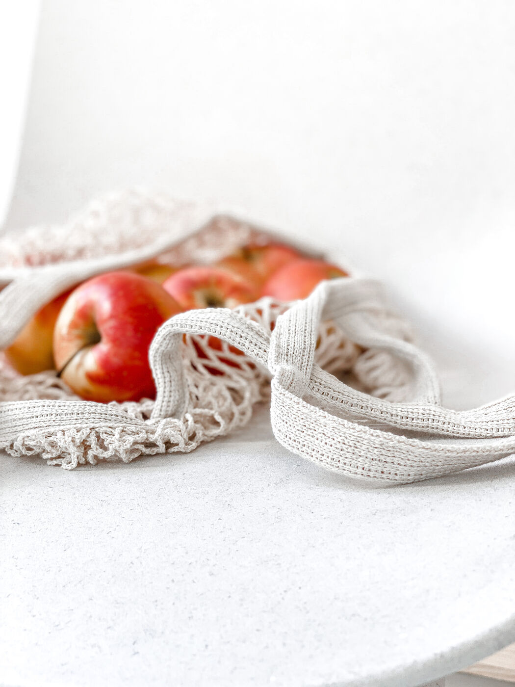 Close-up of apples in a cotton mesh bag